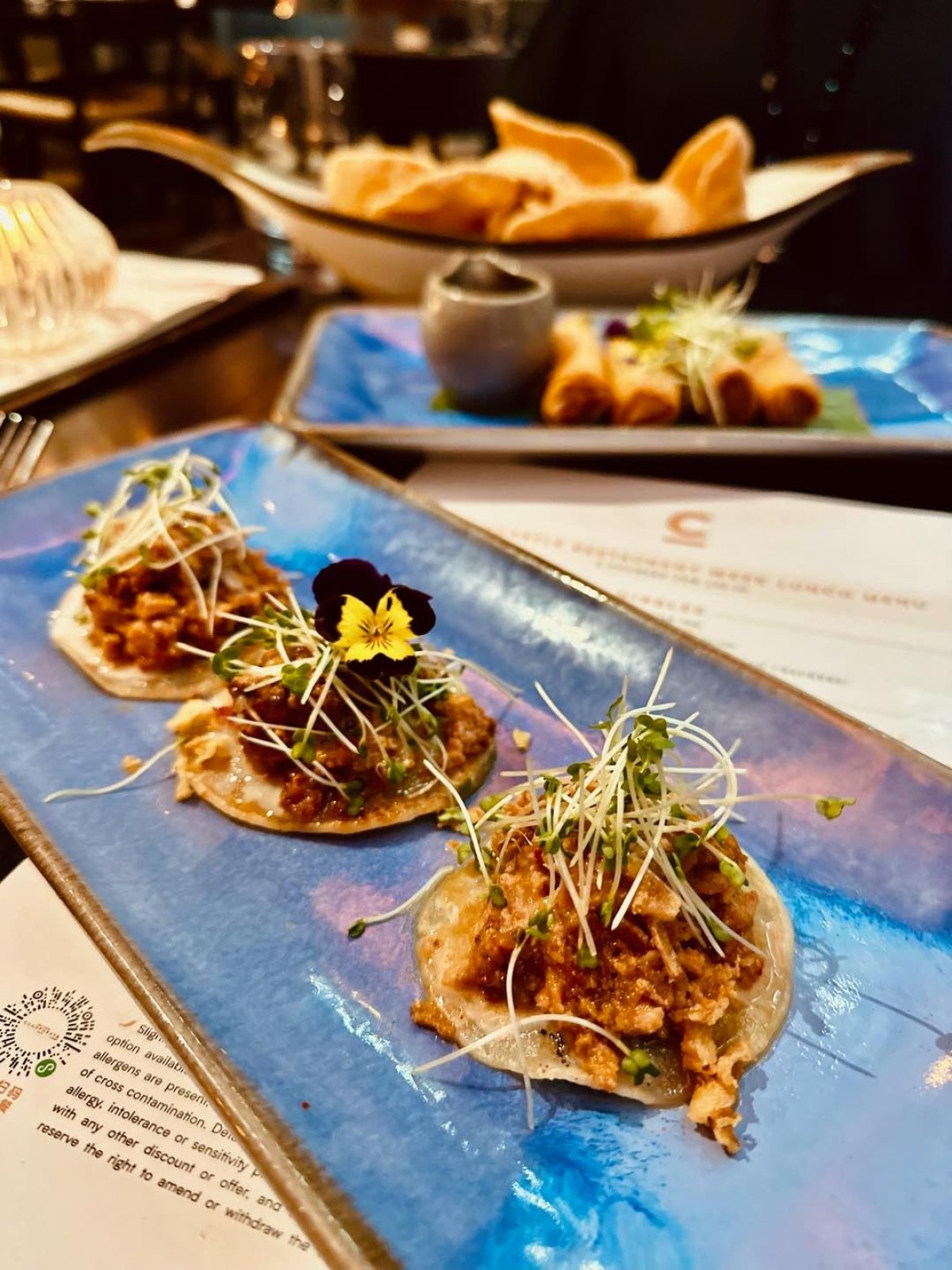 A trio of Thai-style tacos on a blue plate