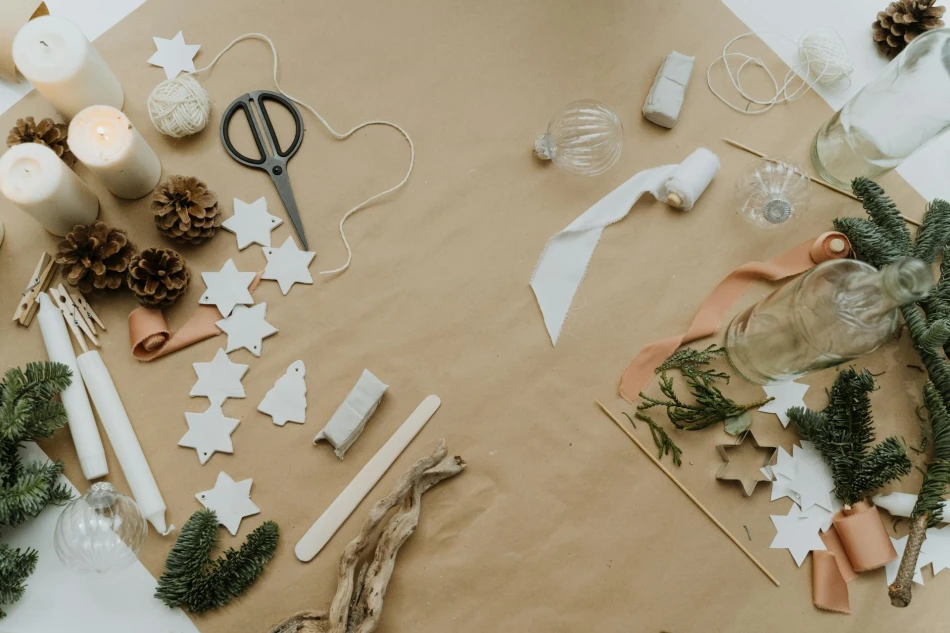 Yarn, scissors and Christmas themed crafts sitting on a piece of brown wrapping paper. Photo by Cottonbro Studio via Pexels